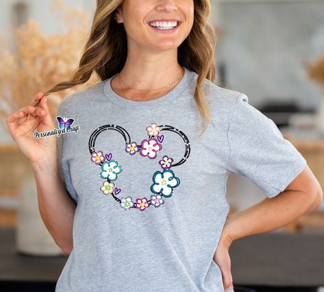 👉 Elevate your wardrobe with a touch of Disney magic! 🎀✨ Our soft shirt featuring the iconic Minnie Mouse silhouette adorned with vibrant hibiscus 🌸 flowers and glitter details is the perfect blend of cute and chic. Add a dash of sparkle to your day and let Minnie's timeless charm brighten every moment. Available now for a touch of Disney whimsy in your style! 👜 SHOP LINK in Bio: www.PersonalizedCraft.net #AffordableDisneyFashion #MinnieMouse #GlitterMagic #HibiscusFlowers #PersonalizedCra... Minnie Mouse Silhouette, Silhouette Head, Princess Character, Mouse Silhouette, Disney Tee, Cozy Day, Family Together, Disney Tees, Disney Fashion