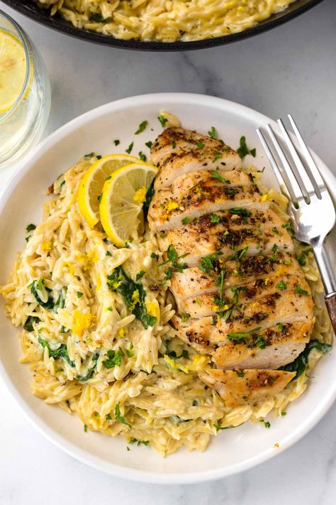 Lemon Chicken Orzo! This creamy one pot lemon chicken orzo is perfect for weeknights, and an amazing comfort food recipe. The orzo is tender, and it's tossed with fresh lemon and spinach. One Pan Lemon Chicken And Orzo, 1 Pan Lemon Chicken Orzo, Lemon Orzo Pasta With Chicken, Creamy Parmesan Orzo With Chicken, Joanna Gaines Lemon Orzo, Chicken With Orzo Recipes, Lemon Orzo Recipes, Baked Chicken And Orzo, Healthy Orzo Recipe