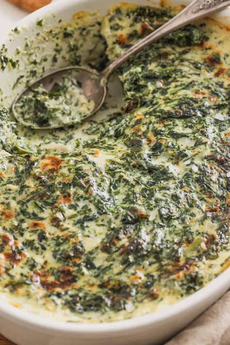 This creamed spinach from frozen spinach is a steakhouse-style recipe that's baked at the end in a casserole dish. It's made without heavy cream but in a creamy, cheesy sauce. It's the perfect side dish for Thanksgiving, Christmas, or holidays and it feeds 8-10 people as written, but can be decreased for a smaller group. The perfect winter potluck dish! Spinach Heavy Cream Recipes, Southern Creamed Spinach, Creamy Spinach Bake, Easy Spinach Casserole Recipes, Creamy Spinach Casserole, Creamed Spinach Recipe Fresh, Spinach Souflee Recipes, Cheesy Spinach Casserole, Thanksgiving Spinach Recipes