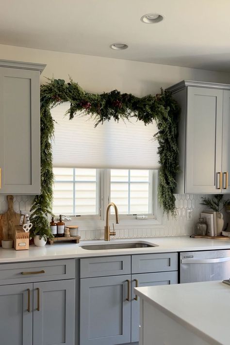 Here's Proof the Viral Christmas Garland Hack Taking Over TikTok Actually Works Garland Over Window Kitchen, Kitchen Island Garland, Garland Over Kitchen Sink Window, Christmas Garland On Cabinets, Christmas Garland Above Kitchen Sink, Above Sink Christmas Decor, How To Hang Garland Over Window, Above Cabinet Garland, Christmas Garland Over Kitchen Window