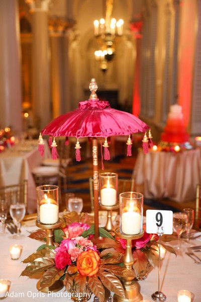 Umbrella, candles and flowers table centerpiece decoration. Mehndi Centerpieces Diy, Indian Party Centerpieces, Mendhi Table Decoration, Indian Table Decorations Party Ideas, Haldi Centerpieces, Dholki Table Decor, Mehndi Decor Centerpieces, Mehendi Centerpieces, Indian Table Centerpieces