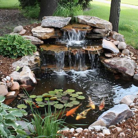 28 Stunning Koi Pond Waterfall Designs - Pond Informer Pond With Creek, Large Garden Ponds With Waterfalls, Fish Pond Ideas Outdoors, Cool Pond Ideas, Backyard Waterfall Pond Ideas, River Rock Pond Backyard Waterfalls, Rock Pond Waterfall, Terraced Water Feature, Landscape With Water Feature