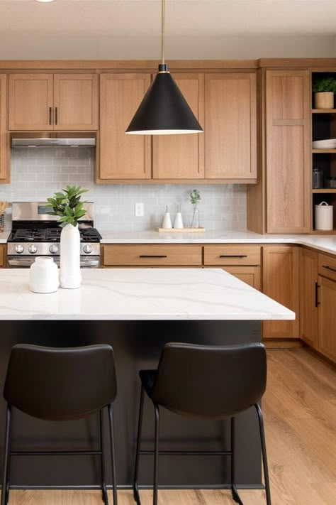 It’s our favorite time of the year! The Spring #ParadeofHomesTC is on now through April 7. 🌷☀️ 🌈  __ Oak cabinets, black kitchen island with black barstools, floating pendants, white countertops, kitchen goals, light wood floors. Dark Floor Dark Counter Kitchen, Light Wood Cabinets With Black Island, Black Island Oak Cabinets, Black Island With Oak Cabinets, Black Kitchen Island Oak Cabinets, White Oak Kitchen Black Island, White Black Oak Kitchen, Black Kitchen Island Wood Cabinets, Oak Cabinets Black Island