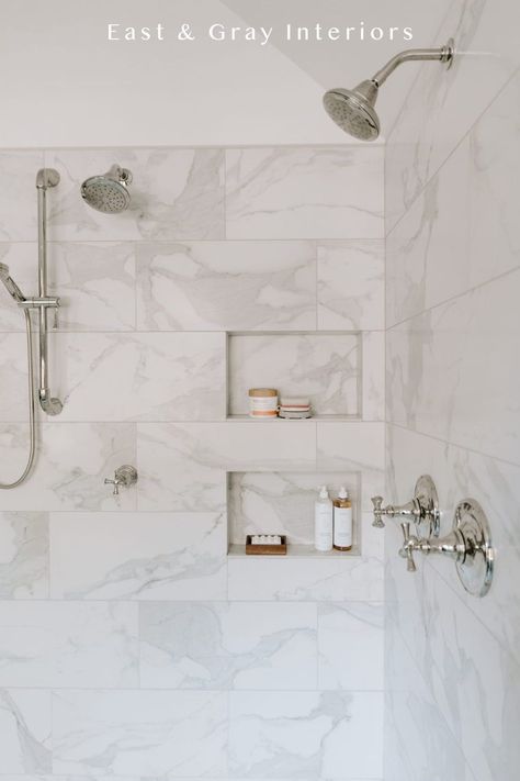 This bathroom design shows off marble like shower tiles with beautiful and functional tile niche! The simplistic design can be both traditional or modern because of its overall timeless look. Want more shower tile ideas? Check out the rest of this bathroom renovation at East & Gray Interiors. Carrera Tile Shower Wall, White Bathroom Gray Floor, Show Tile Ideas, 6x12 Tile Bathroom Shower Walls, White And Gray Tile Shower Ideas, Shower Niche Large Tile, Vertical Marble Tile Shower Walls, Marble Tile Bathtub, 6x12 Shower Wall Tile