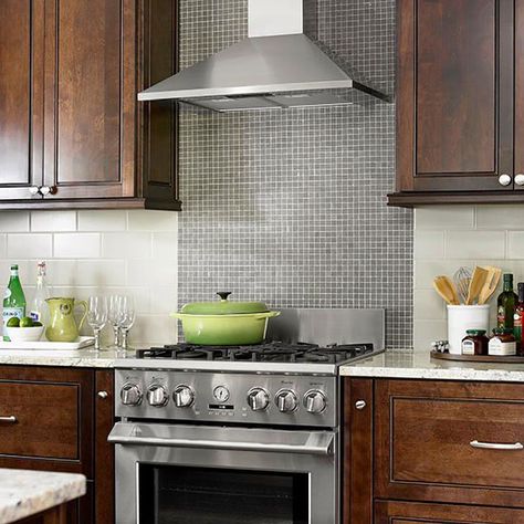 Contrasting Tile BacksplashTiny glass mosaic tiles form the range backsplash in this chic, old-meets-new kitchen. Larger light gray subway tiles run horizontally above the countertop and allow the range backsplash to be the kitchen's standout surface. Hob Backsplash Ideas, Simple Backsplash, Stainless Steel Kitchen Backsplash, Range Backsplash, Range Tile, Patterned Tile Backsplash, Stainless Steel Backsplash, Moms Kitchen, Stove Backsplash