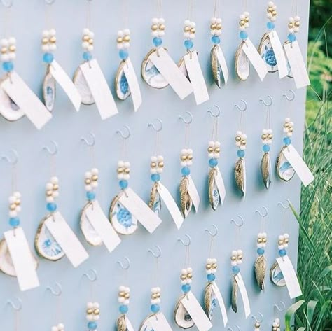 Grit & Grace Studio on Instagram: "⁠ How stunning is this seating chart wall that not only assigned seats but also gifted guests with our Gilded Seascapes collection from @printedhues?⁠ ⁠ When Natalie from @whimevents reached out to us in July, we were beyond excited to contribute to this bride's special celebration.⁠ ⁠ Knowing that our oyster ornaments would be a keepsake for guests to remember the day made us truly honored to be involved.⁠ ⁠ Interested in bulk pricing? Send us a DM or email marketing@gritandgracestudio.com for more details!⁠ ⁠ Planning, Design & floral: @whimevents⁠ Tent: @greenwichtentco⁠ Catering: @katestable⁠ Photo: @perryaile⁠ Video: mapleloft studios⁠ Day of Stationery: @coralpheasant⁠ Rentals: @form_creativeservices @kadeemarentals @laaffitto @peakeventservices⁠ Li Wedding Seating Chart Beach Theme, Wedding Seating Chart Oysters, Beach Wedding Seating Chart Ideas, Seashell Seating Chart, Oyster Shell Seating Chart, Ornament Seating Chart, Oyster Seating Chart, Oyster Shells Wedding, Seating Chart Wall