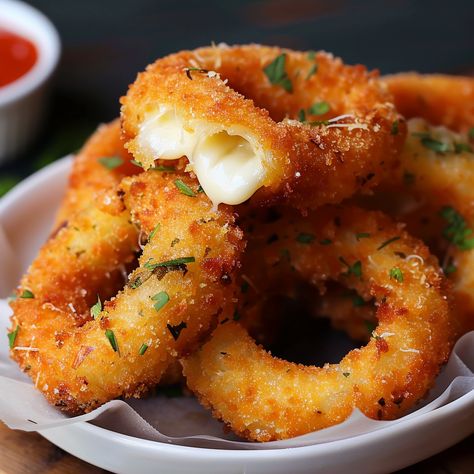 Embark on a culinary adventure with 'Crispy Delight: Mozzarella Stick Onion Rings,' where the beloved appetizer meets innovative cooking. This mouthwatering creation combines the gooey, stretchy joy of mozzarella sticks with the sweet, savory crunch of onion rings, resulting in a fusion snack that's sure to captivate and satisfy. Perfect for parties, game day gatherings, or as a novel treat for family movie nights, these mozzarella stick onion rings offer a fun and flavorful twist on classic ... Mozzarella Stick Onion Rings, Baked Mozzarella Onion Rings, Recipes That Use Mozzarella Cheese, Quick Savory Snacks Simple, Food Cravings Vegetarian, Mozzarella Onion Rings, Mozzarella Donut, Onion Rings Aesthetic, Best Onion Rings Recipe