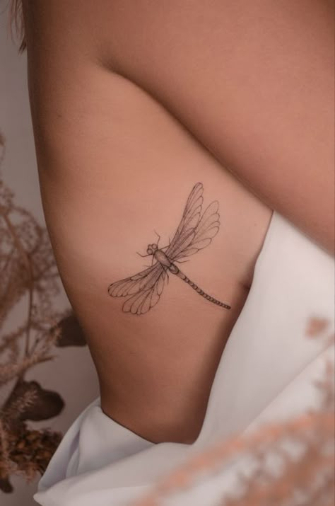 From elegance to mystique, learn about dragonfly tattoos, their symbolism, and the best designs in this article. Dragonfly Tattoo Ribs, Delicate Dragonfly Tattoo, Fine Line Dragonfly Tattoo, Fineline Tattoo Ideas, Tattoo For Woman, Dragonfly Tattoos, Tattoo Snake, Rib Tattoos For Women, Dragonfly Tattoo Design