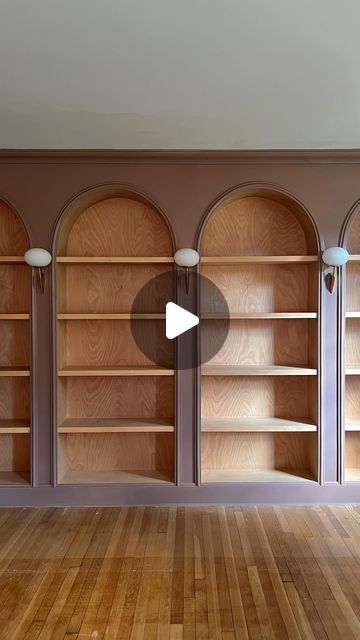 Jourdan Fairchild on Instagram: "Meet our latest—and dare I say greatest—design project to date: a wall of custom arched bookshelves with stained wood interiors and vintage Italian lighting.✨  What started from my sketch on paper in May of last year, my husband Andrew drew directly on the wall with a pencil and then weekend by weekend over 10(!) months built into the grandest focal point in our living room. And he really, truly outdid himself with the level of detail at every seam. I’m honestly blown away by his master-level craftsmanship.   They’re unlike anything I’ve seen elsewhere, make the ceilings feel even higher, and just *feel* right for us and this old home. They’ll certainly make us love where we live a bit more.💕" Built In Bookshelves Vintage, Built In Shelves Library Room, Bookshelves With Arches, Antique Built In Bookcase, Custom Bookcases Built Ins, Vintage Wall Bookshelf, Arched Built Ins Office, Arched Shelf Built In, Arched Library Wall