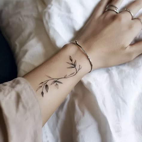 50 Super Cute Wrist Tattoos For Women You’ll Want ASAP Tattoos Wrapped Around Wrist, Hope Wrist Tattoo, Arm Bracelet Tattoos For Women, Long Wrist Tattoo, Fine Line Tattoos Wrist, Dandelion Wrist Tattoos For Women, Dainty Wrap Around Wrist Tattoo, Fine Line Wrist Wrap Tattoo, Floral Wrist Tattoos For Women