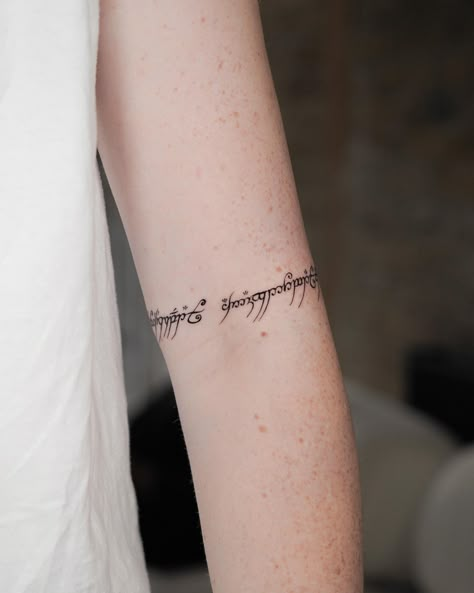 Steel and Elvish script etched into skin, inspired by the tales of Middle-Earth. The shards of Narsil and the iconic inscription of the One Ring. ⚔️🖋️ . . #TolkienTattoo #LordOfTheRings #MiddleEarthInk #Narsil #OneRing #TattooArt Elven Script Tattoo, Lotr Tattoo Minimalist Elvish, Middle Earth Tattoo Ideas, I Am No Man Tattoo Elvish, Simple Lord Of The Rings Tattoos, Lotr Elvish Tattoo, The Lord Of The Rings Tattoo, Lotr Tattoo Elvish, Shards Of Narsil Tattoo