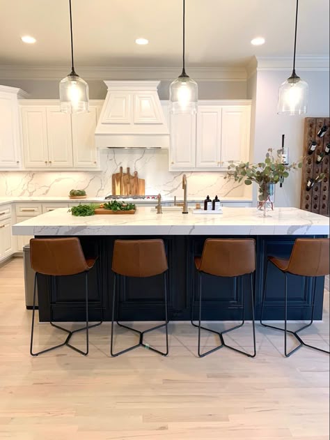 Kitchen with white cabinets, blue island, brass hardware, wood accents, and metal & leather barstools. Designed by L Reaves Interiors. #LRIdesign #LReavesInteriors #kitchen #blueisland #quartzcounter #barstools Navy Blue Island With Bar Stools, Colored Kitchen Island With White Cabinets, Blue Accent Kitchen Island, White Kitchen Navy Blue Island Gold Hardware, White Cabinet With Navy Blue Island, Kitchen Island Dark Blue, Kitchen With Dark Island And White Cabinets, White Kitchen With Barstools, Good Hardware Kitchen