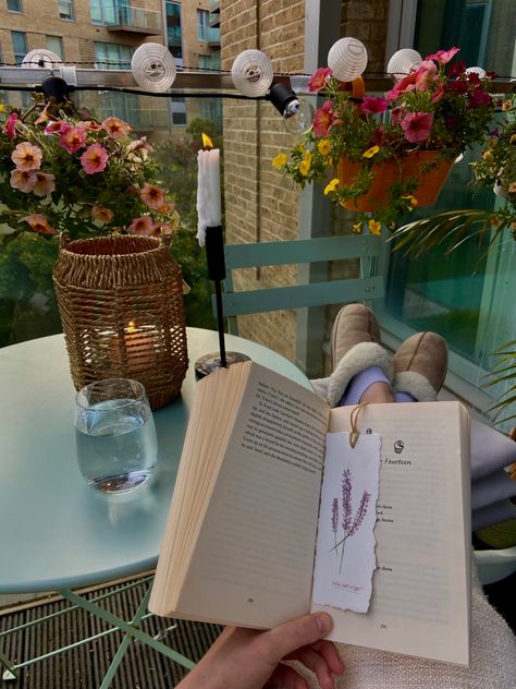 Girl sitting with her feet up reading her book with a handmade watercolor bookmark in on her balcony. The balcony is full of plants and flowers and the sun is setting in the background. Candles are lit and it’s the perfect ending to a day. Living Slow Lifestyle, Reading On Balcony Aesthetic, Slow Living Inspiration, Living With The Seasons, Slow Living In The City, Slow Living Aesthetic Photography, Slow Living Asthetics, Reading On Balcony, Books And Plants Aesthetic