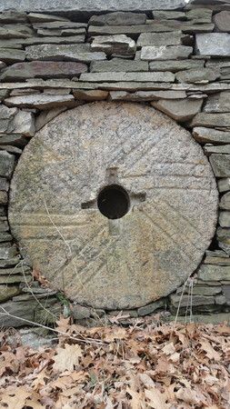 Old grist mill stone set in a stone wall. Grist Mill Stone Ideas, Mill Stone, Old Grist Mill, Stone Fence, Water Wheels, Moon Gate, Rock Walls, Andy Goldsworthy, History Wall