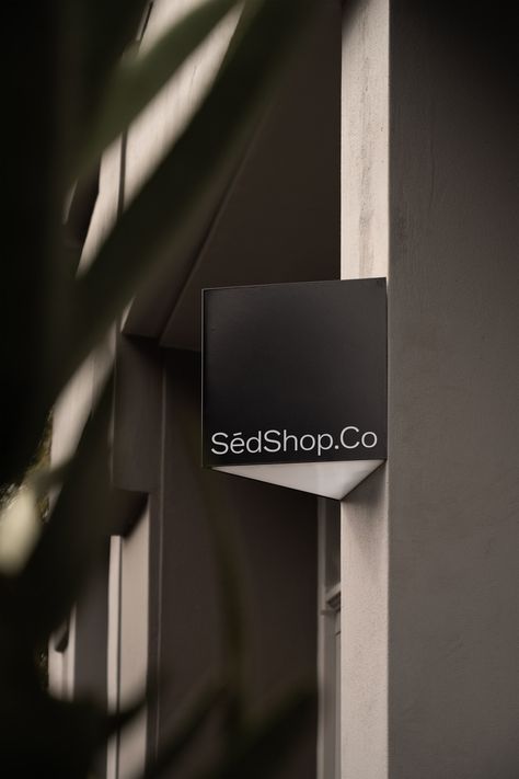 Wall-mounted, black square wall sign in a shaded area, framed by foliage shadows for a sophisticated mockup. Elegant Signage, Building Corner, Signage Mockup, Menu Mockup, Storefront Signs, Free Packaging Mockup, Real Photography, Billboard Mockup, Brand Presentation