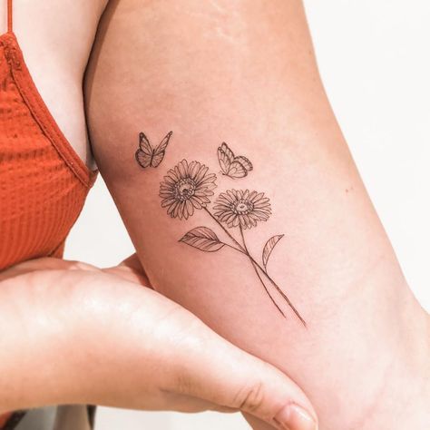 Butterfly With Daisy Flowers Tattoo, Daisy And Butterfly Tattoo For Women, Butterflies Around Flowers Tattoo, Butterfly On Daisy Tattoo, Flower With Butterflies Tattoo, Butterfly Flower Bouquet Tattoo, Bundle Of Daisies Tattoo, Butterfly On Flowers Tattoo, Butterfly With Daisy Tattoo