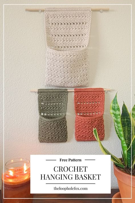 Perfect for those who like to keep things organized and have something pretty and fun to look at, The Millie Crochet Hanging Basket checks off all boxes. This pattern combines a crochet wall hanging with a pouch-like crochet basket to free up your desk or other surfaces by hanging on the wall. Crochet Projects Basket, Hanging Storage Crochet Pattern, Crochet Pattern For Hanging Basket, Crochet Porch Decor, Crochet Hanging Hammock, Crochet Hanging Pattern, Crochet Minimalist Decor, Crochet Housewarming Gift Ideas, Crochet Plant Wall Hanger Pattern Free