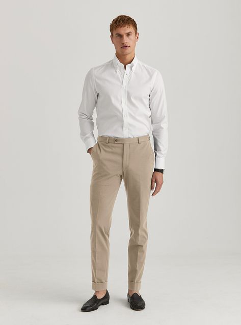 Achieve a chic, polished look with a classic white button-down shirt and tan dress pants, complemented by stylish black slipper loafers. Perfect for those who appreciate a clean and sophisticated outfit for any professional or social occasion. Men White Shirt Outfit, Celana Khaki, Tan Pants Men, Men Wedding Attire, Men Wedding Attire Guest, Beige Pants Outfit, Cream Linen Pants, Slipper Loafers, Tan Dress Pants