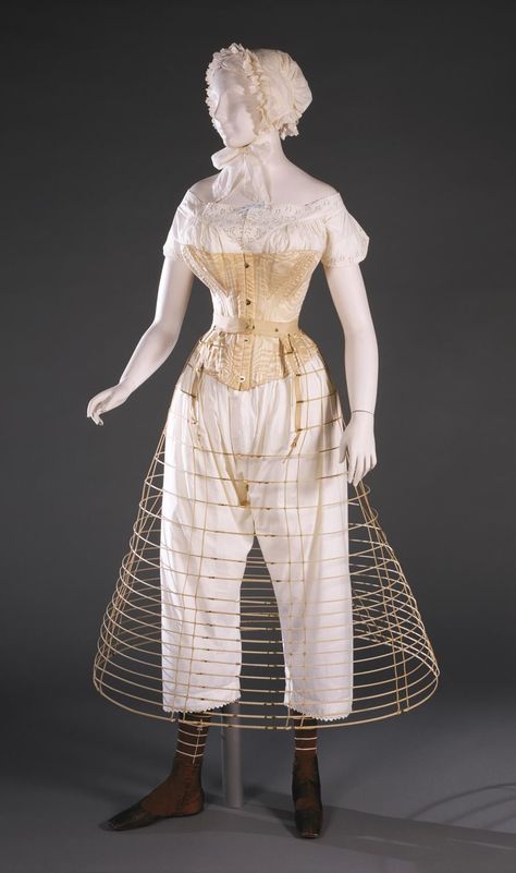 National Underwear Day—This fashionable woman in the 1860s is wearing a chemise and drawers, a corset was gusseted and boned to give a full bust and hips and small waist, a hoop skirt supported a wide skirt, and several smoothing petticoats would also be added. Are you feeling cooler now? Diy Corset, Stockings And Boots, Mannequin Dress, Hoop Skirt, Philadelphia Museum Of Art, Antique Clothing, Little Women, Historical Dresses, Vintage Lingerie