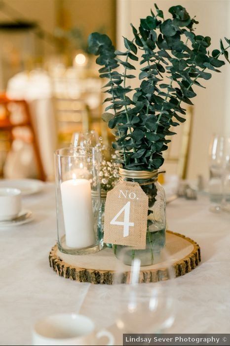 1 Tier Wedding Cake Rustic, Candle And Mason Jar Centerpieces, Wedding Table Decor With Greenery, Modern Rustic Theme Wedding, Dried Eucalyptus Centerpiece, Rustic Modern Wedding Centerpieces, Rustic Wedding Table Decor Mason Jars, Mason Jar Table Numbers, Diy Wedding Decorations With Cricut