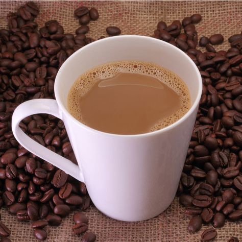 A cafe au lait next to coffee beans. National Days In February, Bake Aesthetic, Indian Pudding, Café Mocha, Irish Coffee, Coffee Milk, National Day, Tea Or Coffee, Tortilla Chips