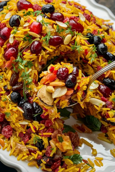 Colorful rice pilaf garnished with dried fruits, nuts, and herbs. Persian Cranberry Rice Pilaf, Jewel Rice Persian, Persian Rice And Chicken, Jewelled Rice Persian, Jeweled Rice Recipe, Persian Shrimp And Rice, Christmas Rice Recipe Dinners, Persian Dishes Recipes, Arabic Rice Recipes Middle East