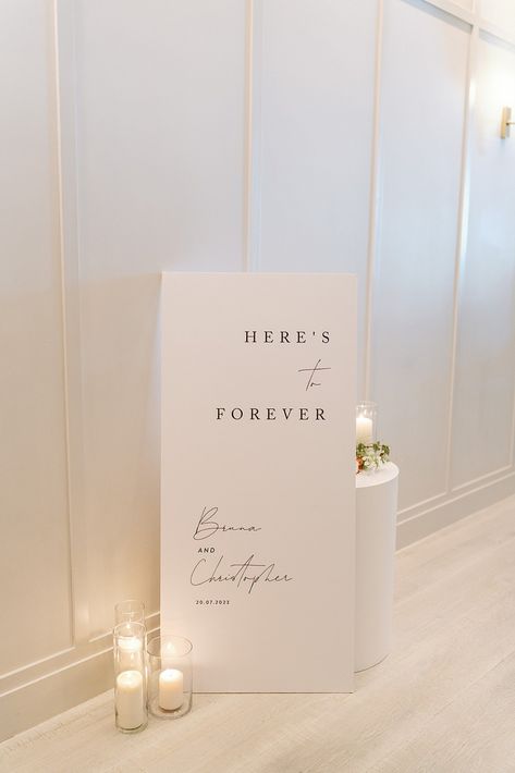 White Here's to forever welcome sign black script Minimalistic Modern Wedding, Day Of Signage Wedding, Wedding Signage Fonts, Wedding Sign Reception, Modern Elegant Wedding Signage, Sinages Design For Wedding, Wedding Table Modern, Wedding Signage Quotes, Minimal Wedding Sign