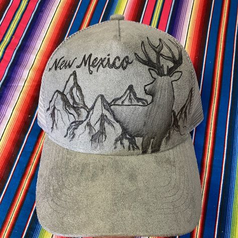 Anyone else in New Mexico getting "buck fever" yet? This burned ball cap is **available** let us know if you want the link to purchase before we take it to the @railyardsmarket.abq this Sunday 🦌⛰️ New Mexico Mountains, Mexico Mountains, Mule Deer Buck, Wood Burning Techniques, Doll Hats, Deer Buck, Painted Hats, Mule Deer, Unique Hats