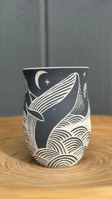 Ceramic Artist, Zahava Friedman on Instagram: "I often struggle to decide whether to try new designs or refine old ones. This is a bit of both. I’ve been working on waves for a while but it’s my first whale, what do you think? Wheel thrown ceramic mug with freehand sgraffito. Follow @innerlightpottery for more adventures in clay! #sgraffito #oceanart #potterylovers #handmadepottery #wheelthrownpottery #handmademug #whaleart #ceramicas #sgraffitoceramics #illustratedceramics #ceramicarts #freehand #amacovelvetunderglaze #lagunaclay" Sgraffito Animal Designs, Sgraffito Designs Pottery, Scrafitto Ceramic Mugs, Pottery Sgraffito Ideas, Drawings On Ceramics, Wheel Thrown Mug Ideas, Pottery Etching Ideas, Scrifito Ceramics, Scraffito Mug