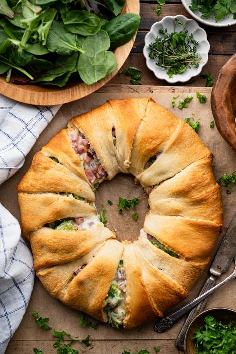 Ham and cheese crescent rolls bake in a ring for an easy-to-serve, easy-to-slice weeknight dinner or crowd-pleasing appetizer. The ham, cheddar, and broccoli crescent ring is flaky, golden brown, and stuffed with a creamy, cheesy, and flavorful filling. It's delicious alongside a simple salad, potato chips, or fresh fruit. Ham And Cheese Wreath Crescent Ring, Ham And Cheese Crescent Ring, Broccoli Ham Ring, Recipes With Crescent Rolls, Ham And Cheese Crescent Rolls, Ham And Cheese Crescent, Cheese Crescent Roll Recipes, Crescent Roll Bake, Easy Crescent Roll Recipes