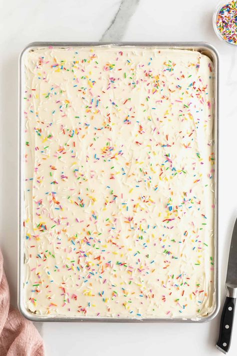 A sheet pan of cookies covered with white frosting and rainbow sprinkles. Bar Cookies Recipes For A Crowd Sheet Pan, Bar Cookie Recipes For A Crowd Sheet Pan, Half Sheet Pan Cookie Bars, Sugar Cookies Bars Recipe, Sheet Pan Bar Recipes, Sheet Pan Cake Mix Cookie Bars, Big Batch Bars Sheet Pan, Sugar Cookie Sheet Cake, Cookie Cake Sheet Pan