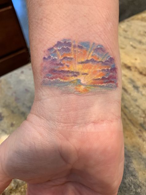 Small sunset tattoo on inner wrist; by artist Layla Hege. Sunset Wrist Tattoos For Women, Unique Sunset Tattoo, Watercolour Sunset Tattoo, Pink Sunset Tattoo, Sunset Sky Tattoo, Sunset Tattoo Minimalist Colored, Watercolor Sunrise Tattoo, Sunset Chaser Tattoo, Rainbow Sunset Tattoo