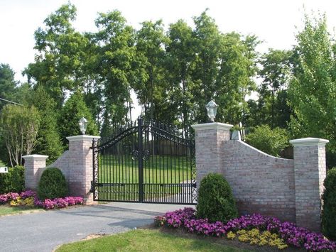 The contrast of the gray stone fence and black iron gate gives an elegant look with a strong feel. Farm Gates Entrance, Landscaping Entrance, Entrance Gates Driveway, Gated Driveway, Entrance Landscaping, Driveway Entrance Landscaping, Farm Entrance, Ranch Gates, Estate Gates