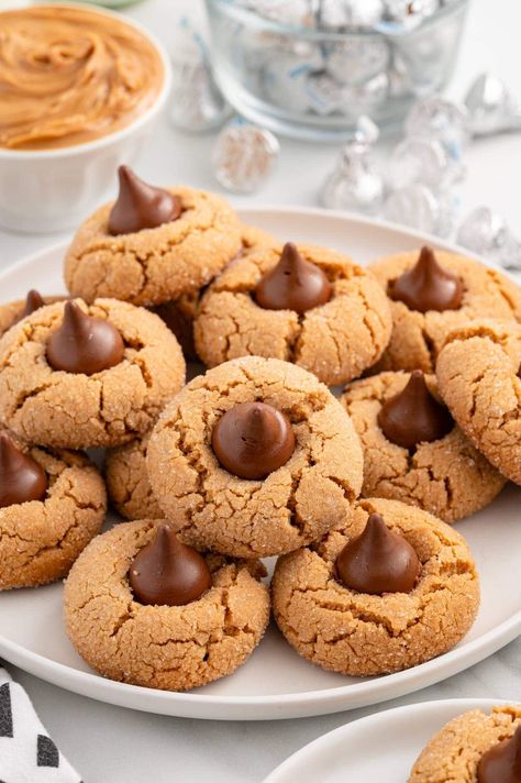 a couple of peanut butter kiss cookies on a white plate. Peanut Butter And Kisses Cookies, Peanut Butter With Kisses Cookies, No Bake Peanut Butter Blossoms Hershey Kiss Cookies, Jif Peanut Butter Blossoms, Pb Kiss Cookies Peanut Blossoms, Peanut Butter Kisses Cookie, Peanut Butter Kiss Cookies Easy, Peanut Butter Cookies With Chocolate Kisses, Chocolate Reeses Peanut Butter Cookies