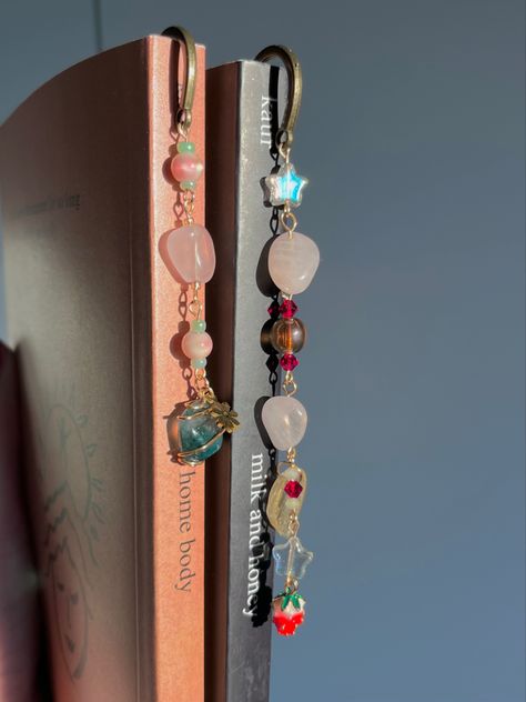 Rose quartz + moss agate bookmark on the left, rose quartz strawberry bookmark on the right 🥰 Available on depop : mini_styles ʚ♡ɞ Diy Bookmarks Beads, Charm Bookmark Diy, Metal Bookmarks Diy, Bead Bookmark Diy, Bookmarks Beads, Beaded Bookmarks Diy, Bookmark Jewelry, Chain Bookmark, Bead Bookmarks