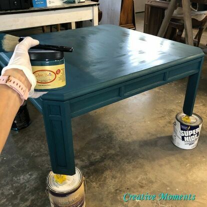 This square light oak coffee table is no longer blah and boring.. it is now boho beautiful with paint. Let me share how I achieved this.Pop over to my blog for more free home decor and furniture tutorials. Clean project    Step 1 is to always clean your piece really well after sanding any loose finish. Paint the table    I brushed on Dixie Belle antebellum blue paint over all surfaces. Add another color    Next was Dixie Belle peacock blue paint randomly brushed all over and blended in… How To Paint A Coffee Table, Boho Coffee Table Diy, Coffee Table Color Ideas, Painting Coffee Table Ideas, Colored Coffee Table, Coffee Table Makeover Diy, Peacock Blue Paint, Refurbished Coffee Tables, Paint Coffee Table