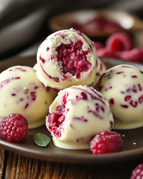 White Chocolate Raspberry Cheesecake Balls - recipestasteful Homemade Chocolates Recipe, Best Cake Balls Recipe, White Chocolate Raspberry Cheese Balls, Nye Baking Ideas, White Chocolate Cheesecake Balls, White Chocolate Raspberry Recipes, New Years Desserts Party, Raspberry Balls Recipe, Jelly Fruit Balls