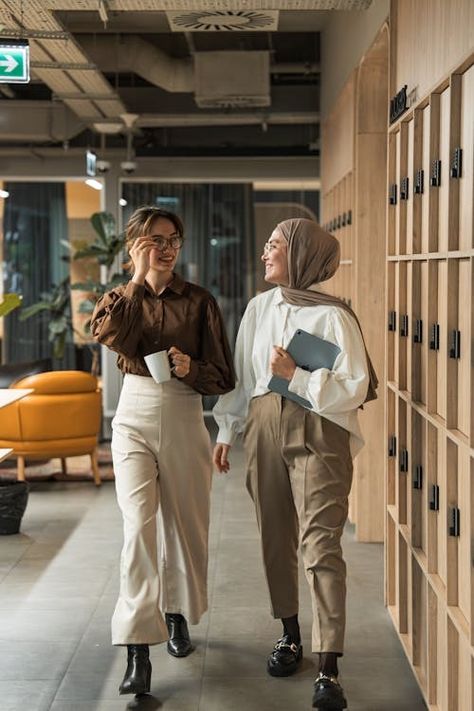 Two women walking down a hallway in an office building · Free Stock Photo Working With Women, People In Office Photography, Casual Corporate Photoshoot, Office Workers Photography, Office Photo Shoot Ideas, Work Office Photography, Corporate Team Photoshoot, Office Content Ideas, Office Team Photoshoot Ideas