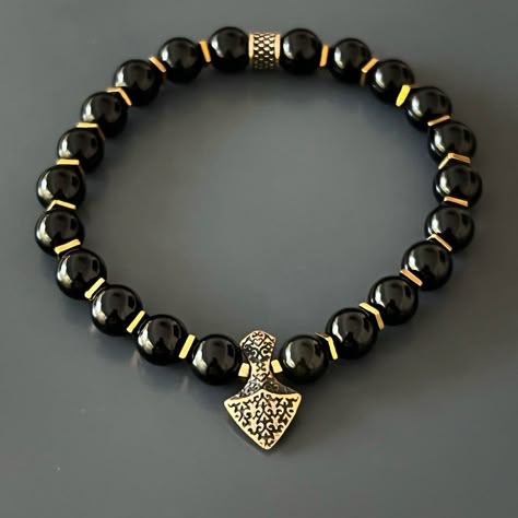 The Arrow Black Onyx Stone Men's Beaded Bracelet is the perfect statement piece for the modern man. The combination of energetically strong black onyx stones and a handmade bronze arrowhead charm creates a unique and powerful design. Black onyx is believed to absorb negative energy and promote inner strength, while the arrowhead symbolizes courage, confidence, and the spirit of a warrior. This handmade bracelet is not only a stylish accessory, but also a powerful tool for spiritual growth and pe Hand Beads For Men, Men Beaded Bracelet Ideas, Onyx Crystal, Black Arrow, Chic Bracelet, Trends For 2024, Black Onyx Stone, Stylish Bracelet, The Arrow