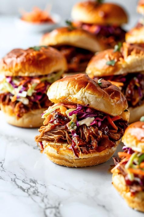 These pulled pork sliders are sweet, savory, and full of goodness! Tender pork is coated in a tangy BBQ sauce and stuffed into Hawaiian rolls. Pork Shoulder Sliders, Mini Pork Sliders, Kalua Pork Sliders With Slaw, Bbq Lunch Party, Pork Bbq Sliders, Pulled Pork Table Set Up, Asian Pork Sliders, Hawaiian Roll Sliders Pulled Pork, Sandwiches Ideas Party