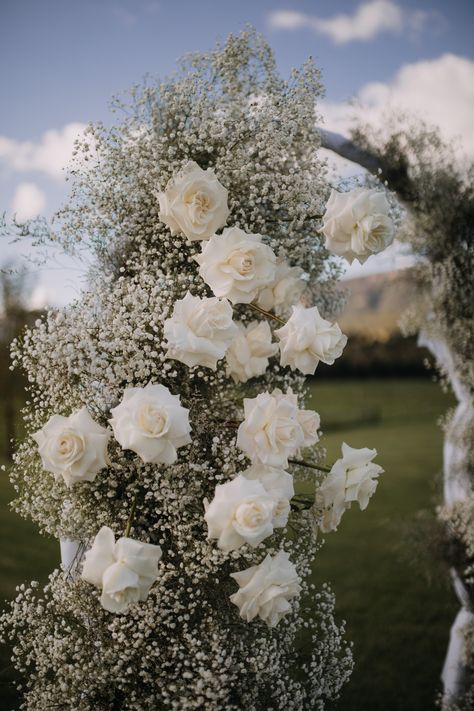 Zoe & Daniel opted for a full arch ceremony filled with babies breath and white roses to create the perfect cloud-like scene. Such a beautiful garden wedding! Captured by zeeandceestudio. Wedding Arch White Roses, Babies Breath Arch, Babys Breath Aesthetic, Wedding Arch Greenery, Black Themed Wedding, White Rose Centerpieces, Eucalyptus Bouquet, White Roses Wedding, White Rose Flower