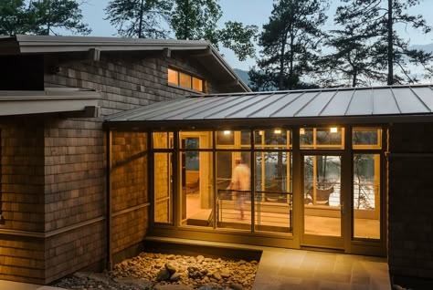 The entry is a contemporary glass-enclosed interpretation of a “dogtrot” – a traditional breezeway connecting two enclosed spaces. Enclosed Breezeway, Glass Walkway, Fontana Lake, Covered Walkway, Breezeway Ideas, Modern Lake House, Mountain Modern, Detached Garage, Modern Exterior