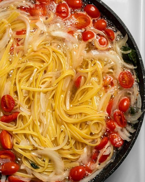 In progress cook with spaghetti noodles, onion, garlic, and cherry tomatoes boiling in water in a cast iron skillet Martha Stewart Pasta, Pan Pasta, One Pan Pasta, One Pot Recipes, Martha Stewart Recipes, Recipe Critic, Stone Farmhouse, Pasta Plates, Spaghetti Noodles