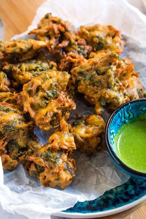 Close up shot of a pile of pakoras served with a small bowl of green chutney. Pakistani Snacks, Aloo Pakora, Onion Bhaji Recipes, Savoury Appetizers, Evening Snacks Recipes, Vegetable Pakora, Chilli Chutney, Saag Aloo, Street Food India