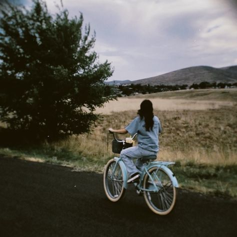 girl riding blue bike with basket on the street with mountain scenery Aesthetic Bikes With Basket, Bike Pictures Aesthetic, Blue Bike With Basket, Bike With A Basket, Bike Riding Astethic, Bike Vision Board, Cycling Vision Board, Summer Cycling Aesthetic, Bike With Basket Aesthetic