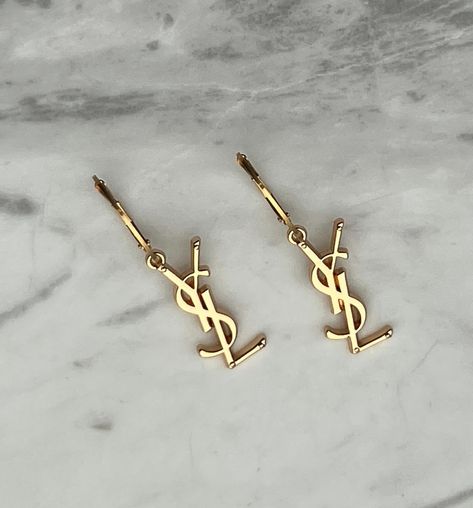 ✨ Beautiful reworked YSL Earrings & Necklaces are now back in stock! ✨ Get yours now before they’re gone again! ✨ Repurposed from authentic pre-loved YSL necklace charms and handcrafted in Melbourne with love 🫶🏼 ✨ Free shipping Australia wide. #yvessaintlaurent #yvessaintlaurentjewellery #repurposedjewelry #vintagejewels #vintageaesthetic #goldjewellery #sustainablejewelry #saintlaurent #prelovedysl #aestheticphotography #vintageysl #reworkedvintage #designerjewelry #ysl #upcycledjewelry #v... Gold Earring Aesthetic, Luxury Must Haves, Ysl Accessories, Ysl Bracelet, Ysl Earrings, Saint Laurent Earrings, Ysl Necklace, Ysl Jewelry, Saint Laurent Vintage