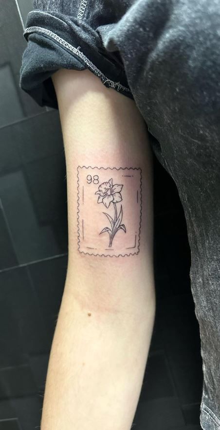 Daffodil Tattoo With Date, Daffodil Postage Stamp Tattoo, Stamp Tattoo Daffodil, Daffodil Carnation Tattoo, Easter Flower Tattoo, Unique Daffodil Tattoo, Daffodil Tattoo Realistic, Daffodil Line Art Tattoo, Daffodil Arm Wrap Tattoo