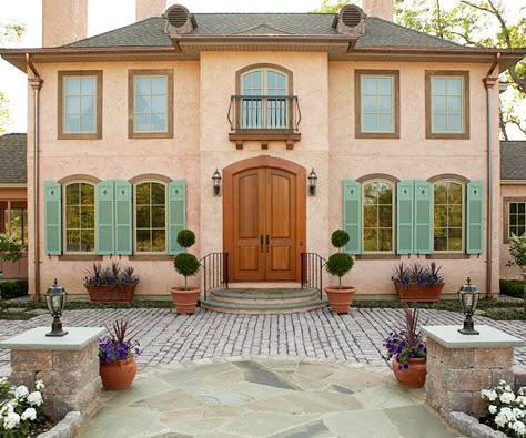 Peach terra-cotta and muted green make a unique color scheme on this symmetrical home. See more home exteriors: http://www.bhg.com/home-improvement/exteriors/?socsrc=bhgpin092212peachterracotta Exterior Color Combinations, Stucco Colors, Best Exterior Paint, Green Shutters, House Paint Color Combination, European Doors, Door Exterior, Glass Railings, Paint Colors For House