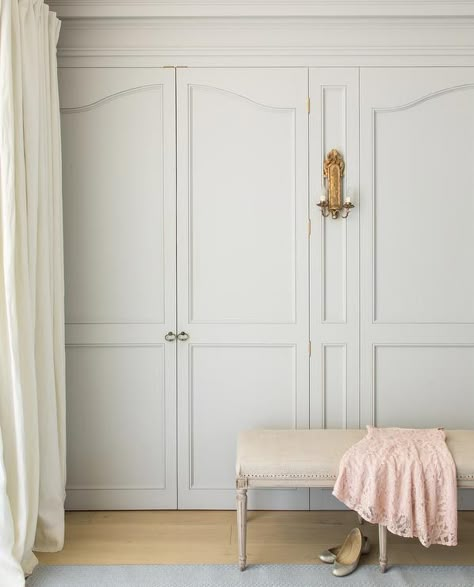 Chic, French closet feature slight gray wardrobe closet doors illuminated by a gold leaf sconce alongside a cream linen French bench. Light Wood House, European Country Home, Gray Closet, French Closet Doors, Grey Wardrobe, Patina Farm, Patina Style, Armoire Dressing, French Wardrobe