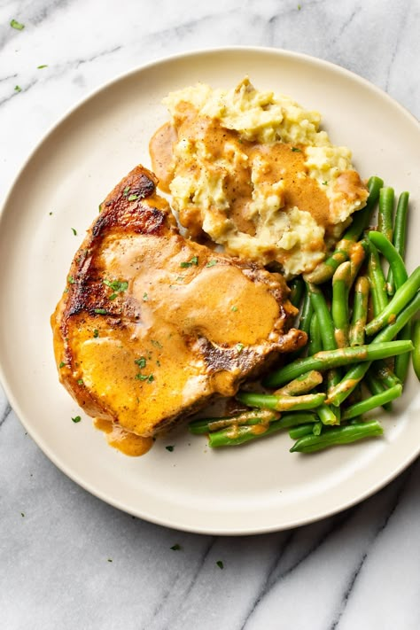 Smothered pork chops are easy to make and incredibly comforting. Use bone-in or boneless pork chops. This delicious family dinner is quick to prepare! They're perfect with mashed potatoes for all that gravy. Best Smothered Pork Chops, Easy Smothered Pork Chops, Pork Chops Bone In, Smothered Pork Chops Recipe, Pork Chops And Gravy, Pork Chops And Potatoes, Delicious Family Dinners, Smothered Pork, Apple Pork